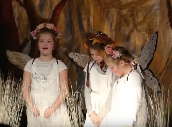 Bühnenszene: Drei Mädchen in langen weißen Elfenkostümen