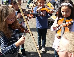 Ein öffentlicher Platz voller kleiner Mädchen mit Geigen.