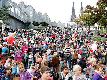 Massen von  Kinder und jungen Familien während des Weltkindertags auf den Rheinterrassen und im Hintergrund sind die Domspitzen zu sehen