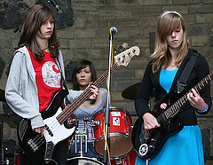 TeenBand - Drei junge Frauen mit elektrisch verstärkten Instrumenten.
