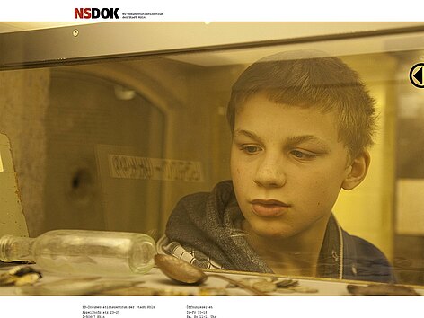 Screenshot der Homepage: Ein Junge beim konzentrierten Betrachten einer Ausstellungsvitrine.