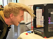 Makerspace: Ein junger Mann beobachtet einen Herstellungsprozess im 3D-Drucker.