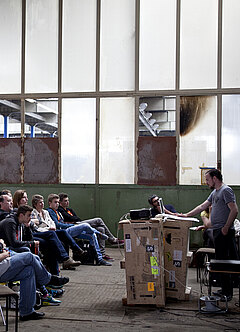 Tagungsszene in Fabrikloft - der Künstler Björn Siebert am improvisierten Präsentationspult.