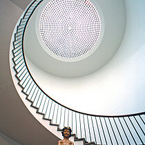 Blick zum  kreisförmigen Treppenaufsprung des Museums für angewandte Kunst mit farbiger Brunnenfigur.