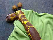 Ein als Giraffe geschminkter Unterschenkel und Fuß auf grünem Tuch
