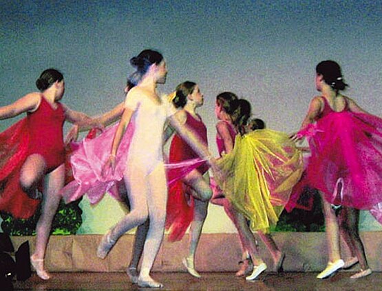Gruppentanz von acht Mädchen in roten und gelben Ballett-Kostümen