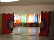 Ein Tanzsaal mit Spiegelwand ist mit bunten Stoffbahnen ausgekleidet.