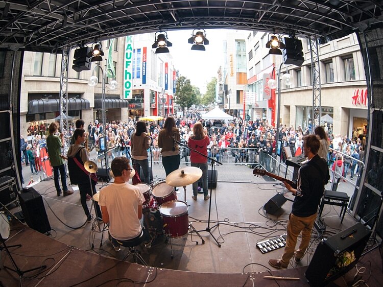 Blick von der Bühne über die junge Band auf ein Straßenfest