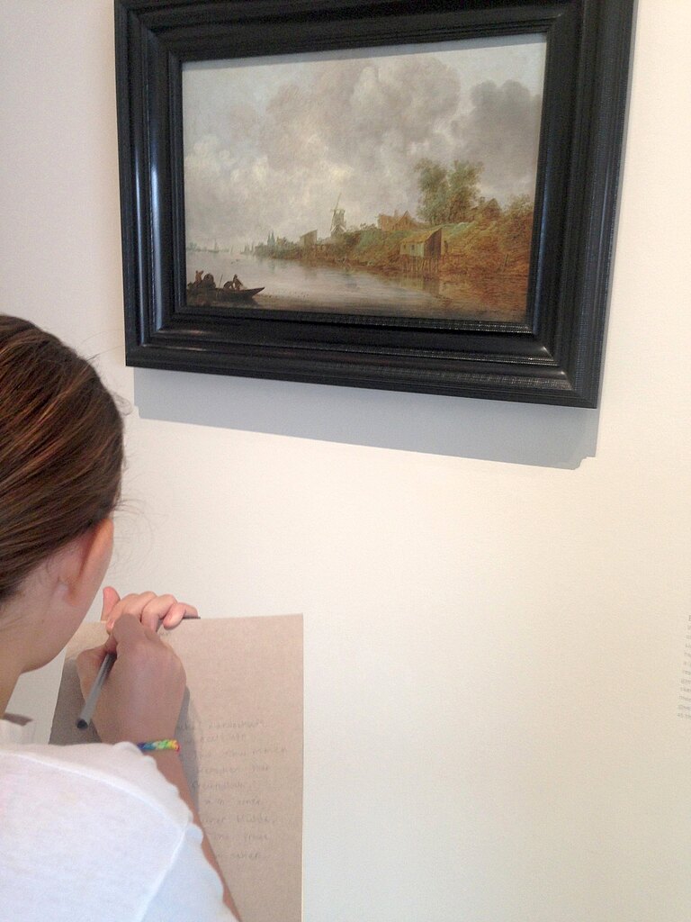 Ein Mädchenkopf von hinten, an der Museumswand ein schwarzgerahmtes Landschaftsgemälde. Das Kind notiert etwas auf einem Block.
