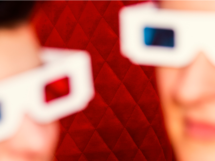 Personen mit einer 3D Brille vor rotem Hintergrund