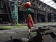 Fotokunst: Ein Mädchen mit Ballons in einer großen maroden Werkshalle